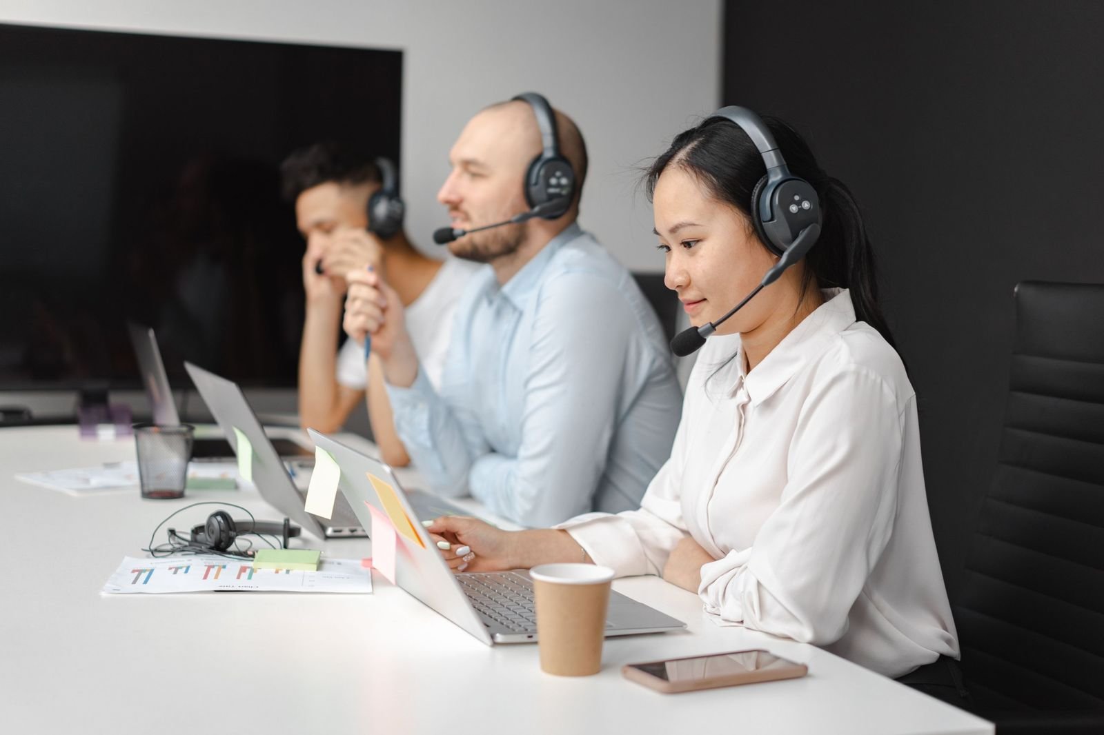 Dispatchers with headsets working on laptops