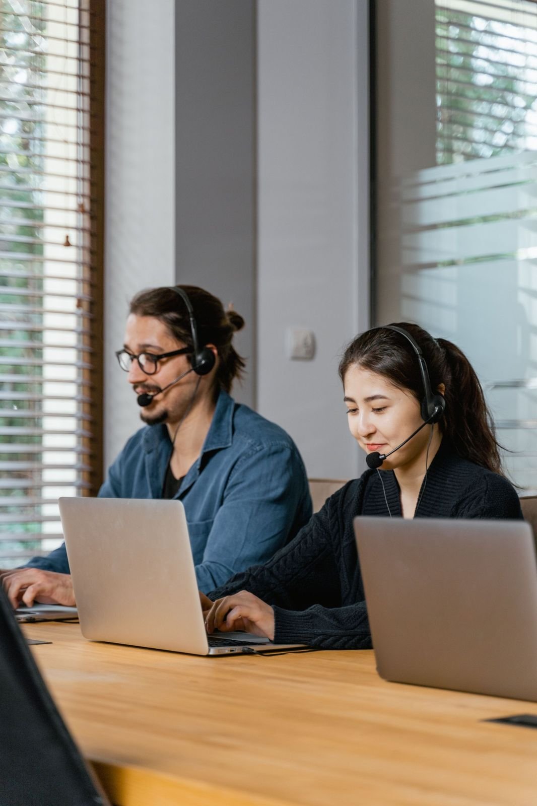 Dispatchers with headsets working on laptops
