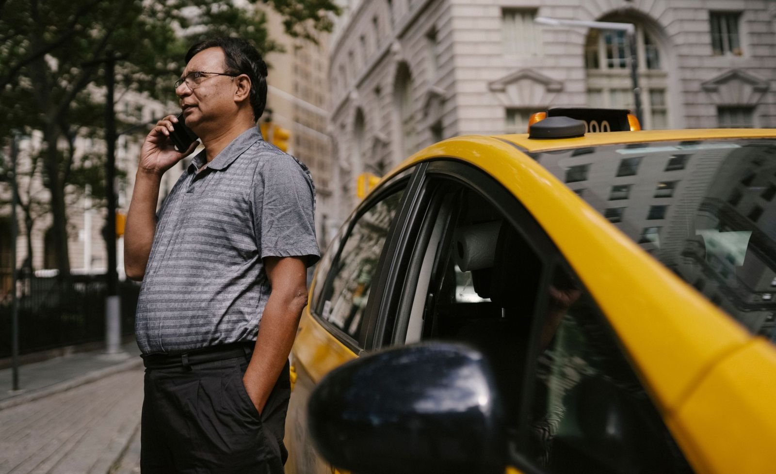 Taxi driver taking a phone call in his car